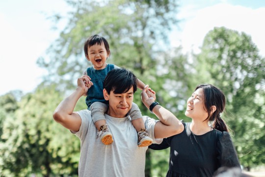 Mother and father with son on shouldres