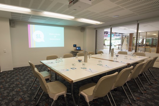 Meeting room 1A at State Library with tables and projector