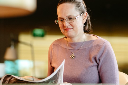 Woman sitting and reading printed material in the State Library. 