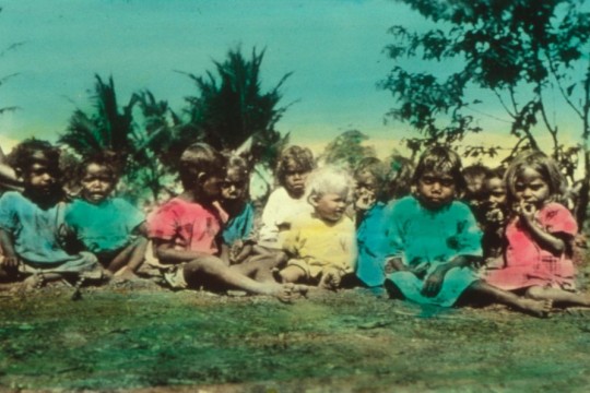 Coloured image of Pastor Schwarzs daughter sitting with several First Nations children c1902