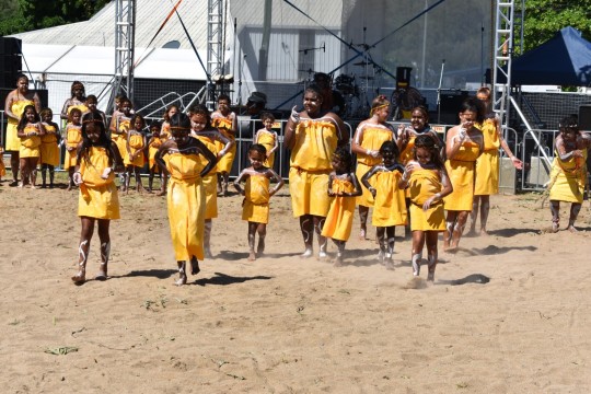 Performance by Yidinji youths dressed in yellow, dancing at Palm Island centenary celebrations, 2018.