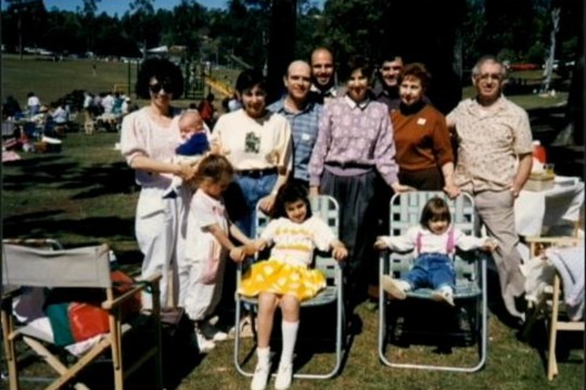 A family gathered outdoors at a picnic- taken from the 1970s 