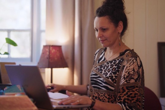 Woman sitting at home using a laptop.