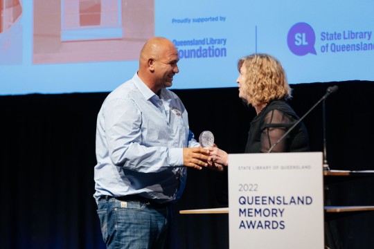 Man accepting an award on stage.