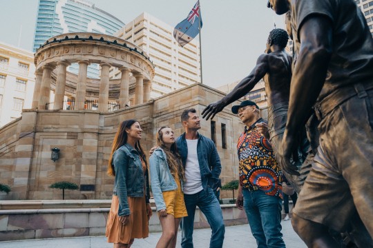 Patrons in front of a statue at Anzac Square