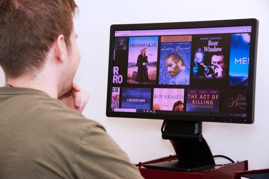 Man looking at Kanopy on desktop computer