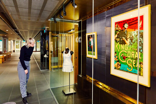 Visitors looking at a collection item in the Talbot Family Treasures Wall.