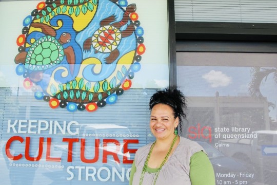 Woman standing beside keeping culture strong sign