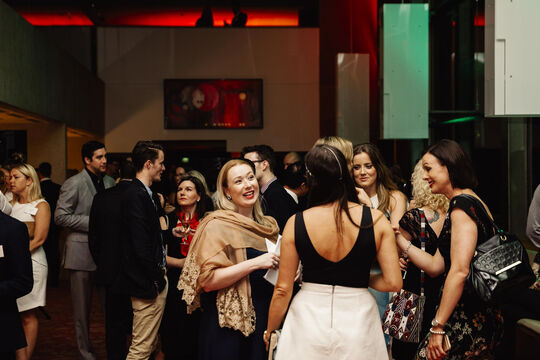 Group of people chatting at a social event at State Library. 