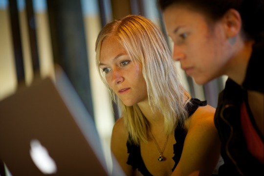 Two women looking at their laptops