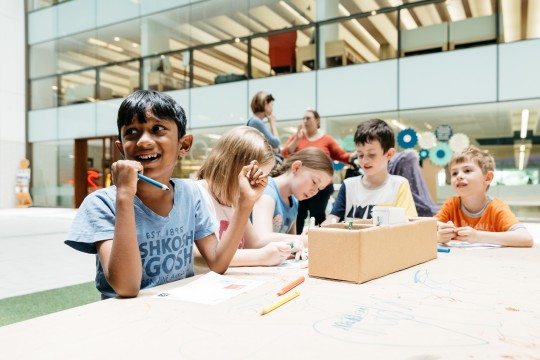 Kids working around a table at the Summer Festival State Library Queensland