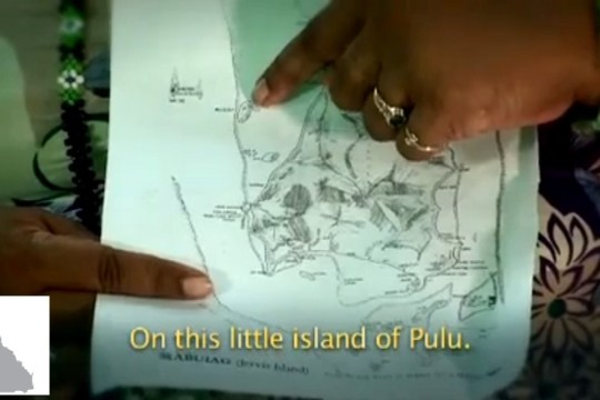 Screenshot taken from the story of Koemuthnab, picturing a person pointing at a map of the island Pulu