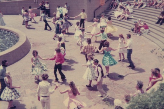 people swing dancing in a concrete square 