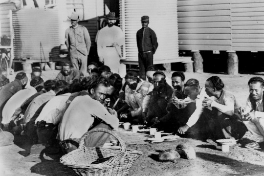 Chinese prisoners being fed under supervision outside in the Goal Yard Burketown Queensland ca October 1900