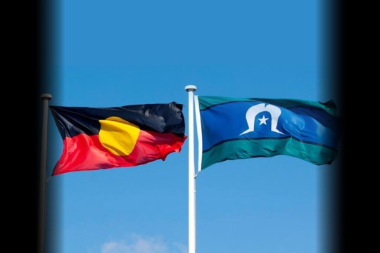 Aboriginal and Torres Strait Islander flags flying in a blue sky