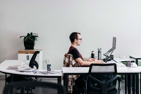 Man using laptop in office. 