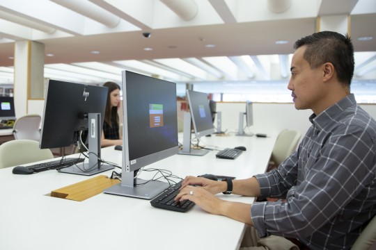 Man using computer at State Library Queensland