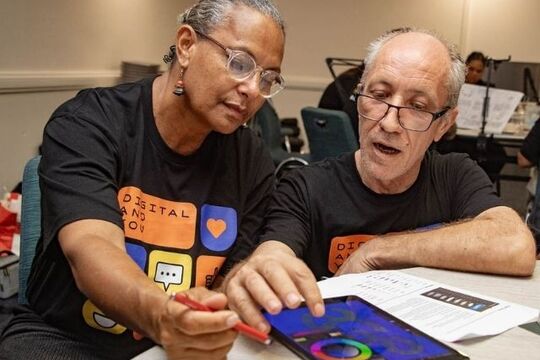 Two people using a tablet.