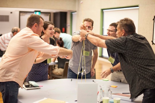 A group of people standing around a table.