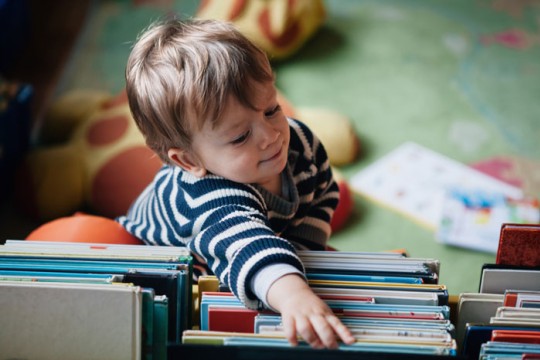 Child reaching for a book.