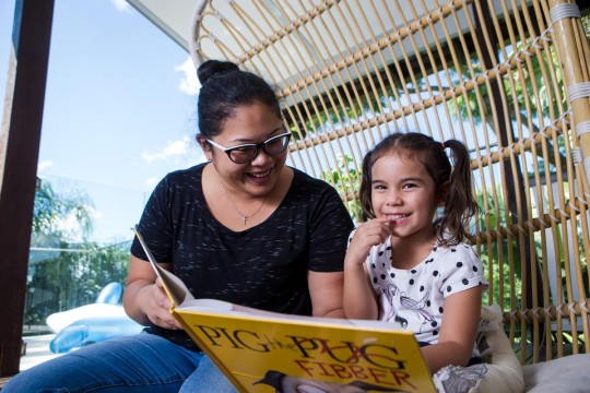 Girl and mother reading outside