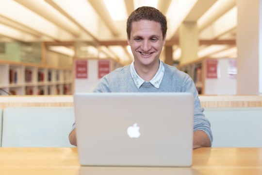 Man using laptop in the State Library of Queensland. Photo by Jeff Camden.