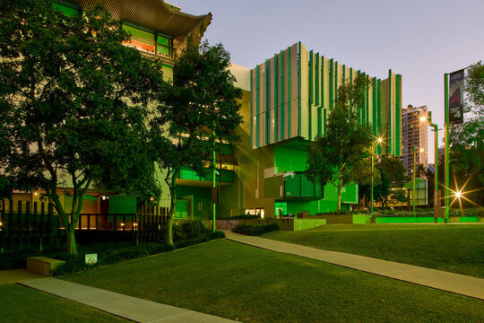 State Library building at dusk with green lights.
