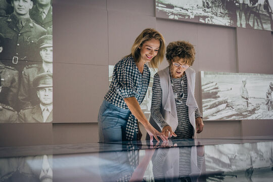 Two people using a touchscreen at Anzac Square
