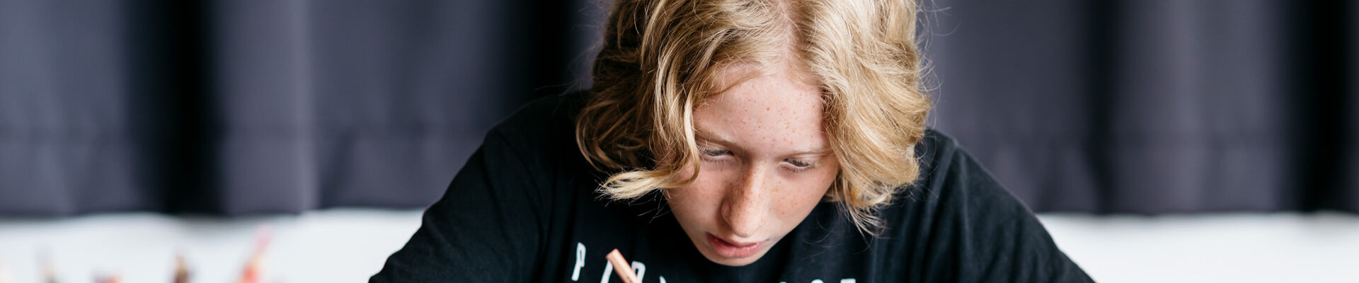 Young person writing in a workshop. Young person writing in a workshop