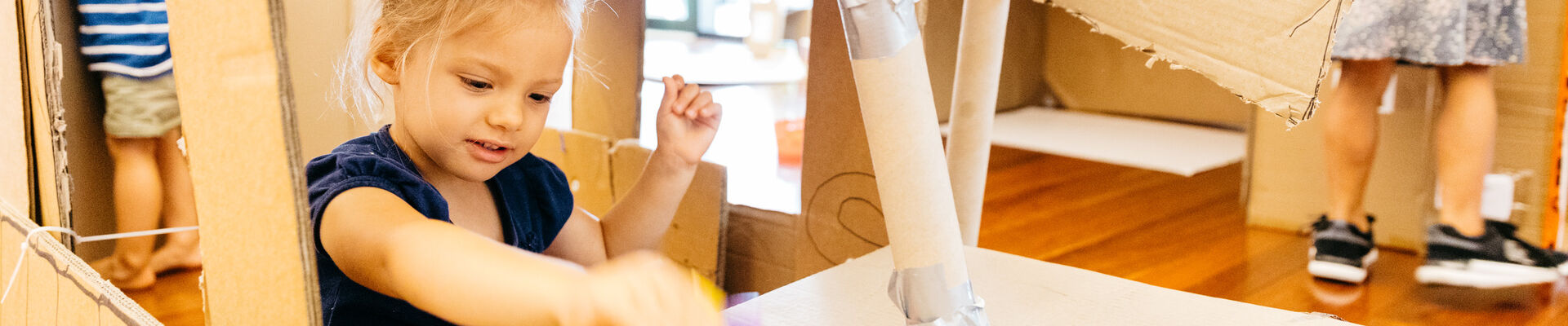 Young girl playing with cardboard
