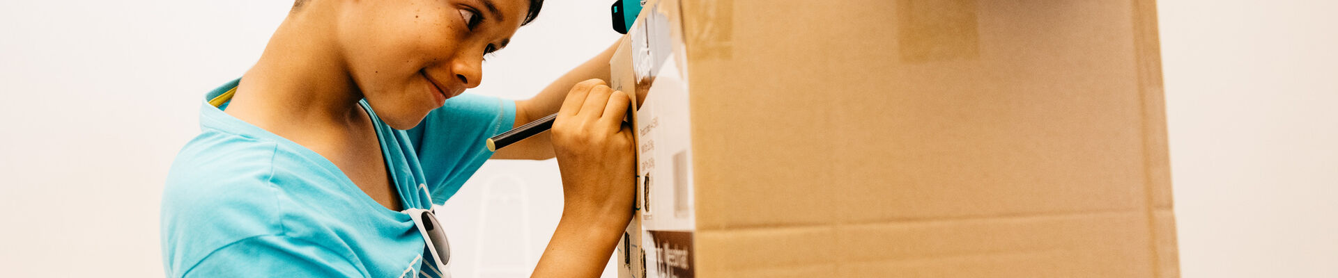 Young boy building cardboard creation