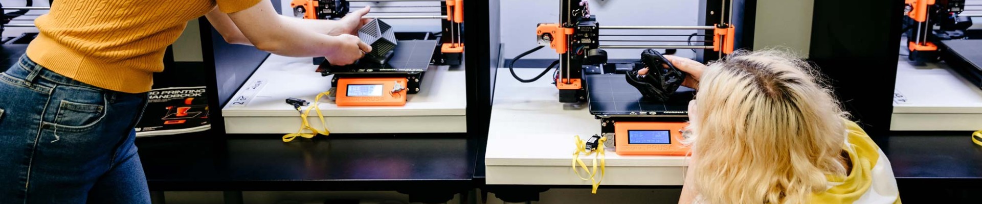 Two people using 3D printers in the Edge