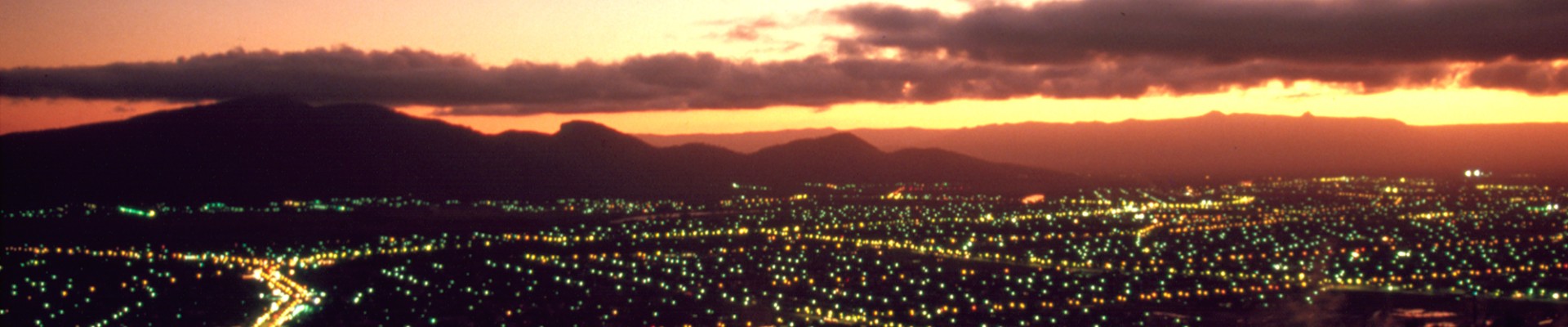 City lights of Townsville twinkle as the sun disappears below the horizon 1985