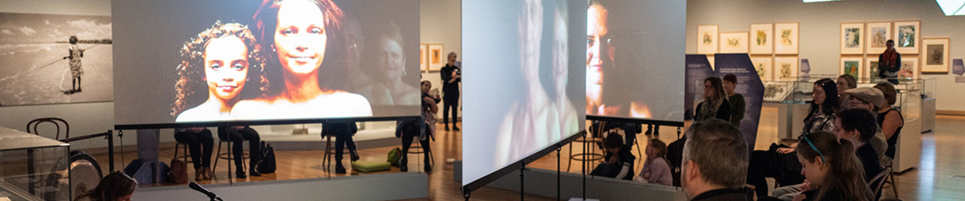 Performance in slq gallery seated guests watch musician seated on floor