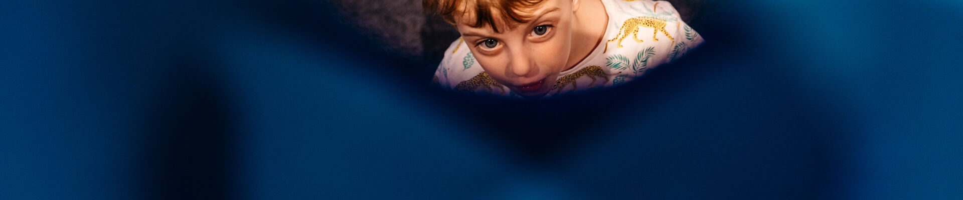Child looking through window of foam structure
