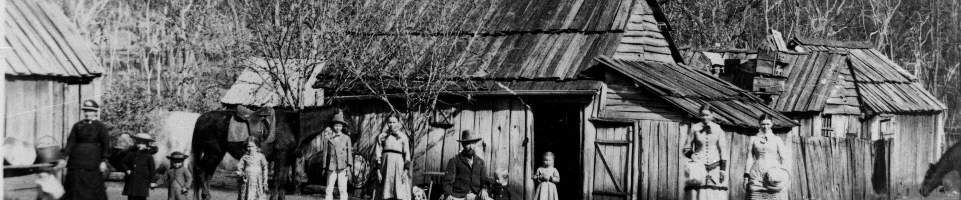First dwelling of a German settler Rosewood Queensland ca 1880 11 people of various ages standing in front of a wooden house and a horse