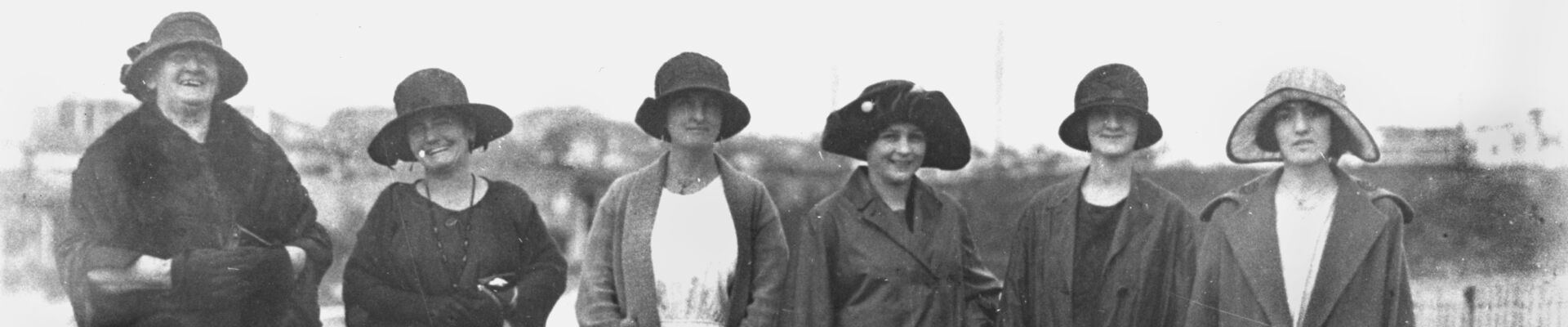 Black and white image of group of women photographed walking along a street 1920-1930