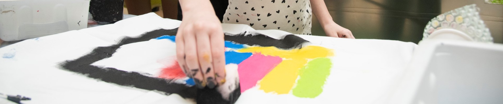 A young person creating a hand stamped tea towel