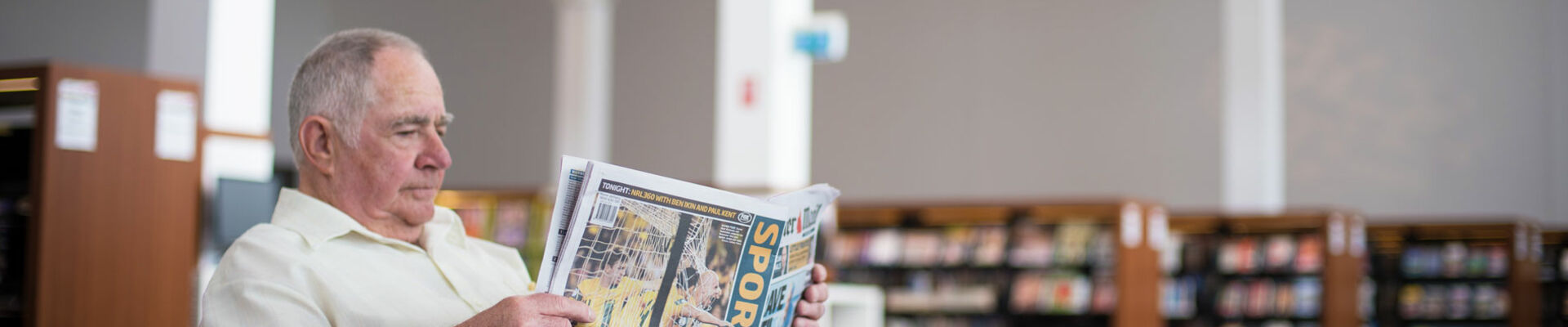 Man reading newspaper in the Caboolture public library
