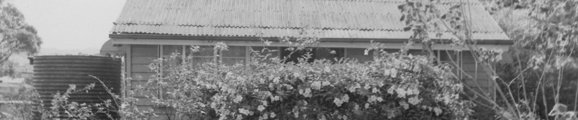 Corley House Photo 6169 0412 0014 Black and white photo of house with garden rain tank and child with pram