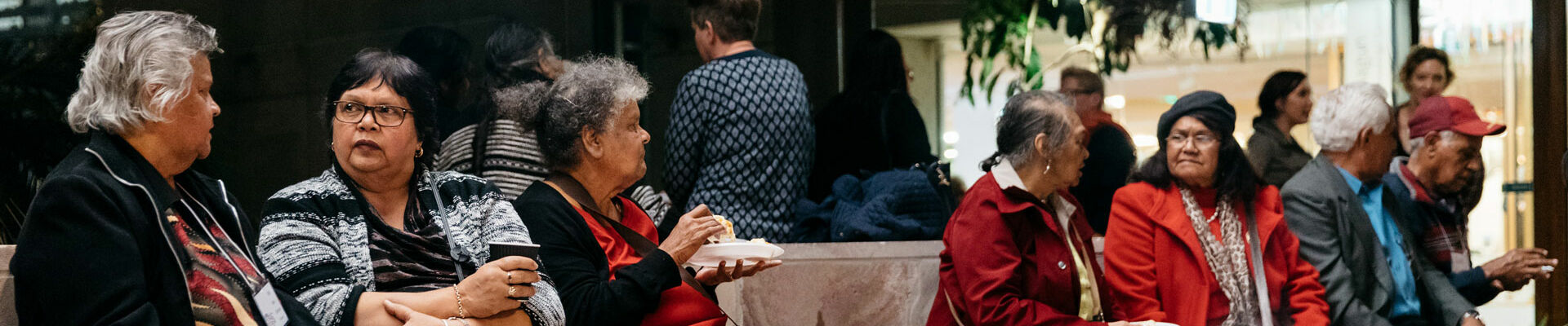Visitors chatting and eating while gathered around a lit fire in the Talking Circle
