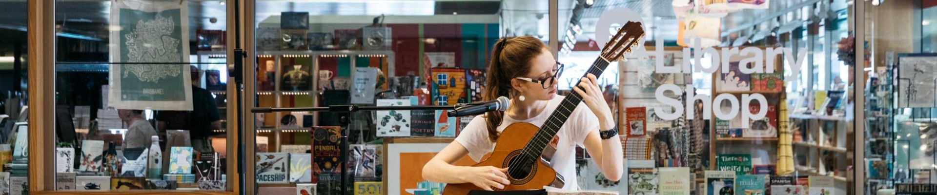 A volunteer musician performing outside the State Library Shop