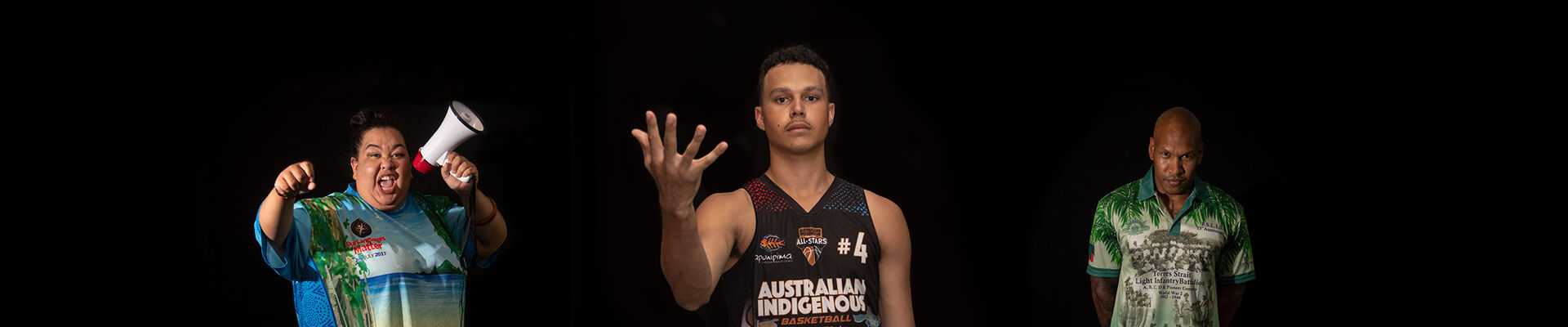 Deadly Threads what's on image lady wearing blue Indigenous shirt with loudspeaker young man wearing singlet throwing a ball in the air and middle aged man wearing green and grey shirt with head slightly bowed