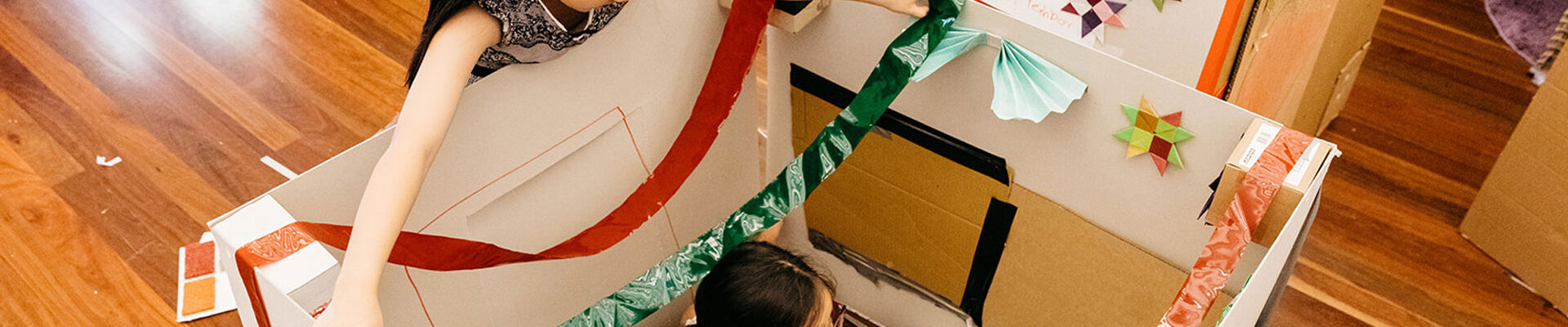 Two children playing in a cardboard box
