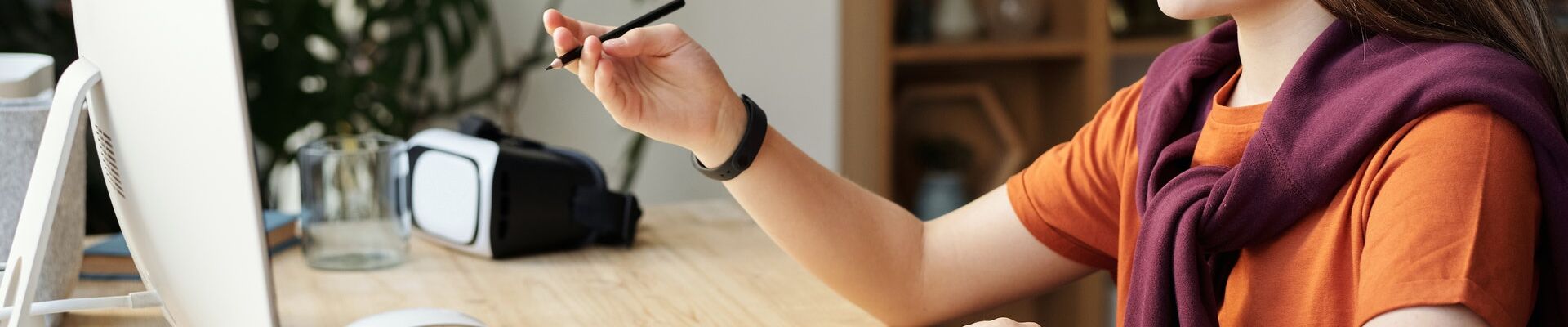 Young teenager writing in front of a computer screen