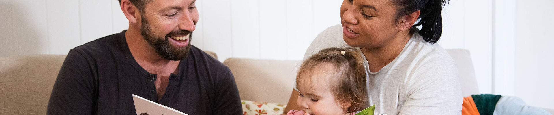 Family reading to small child at home