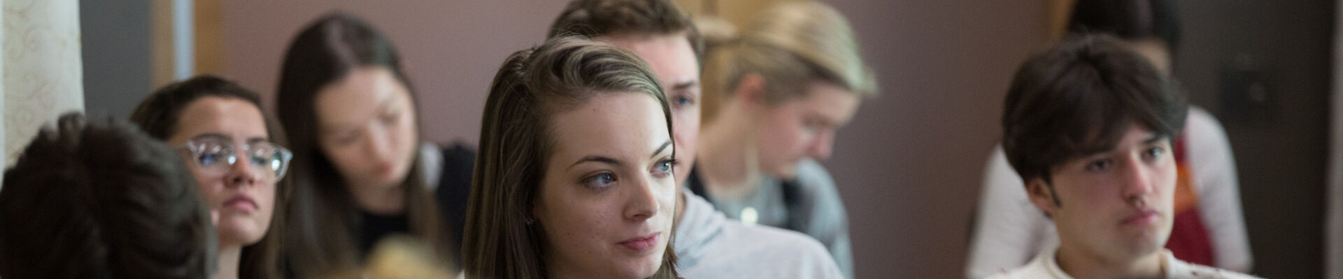 Students listening to a presentation Group of students listening to a presentation main focus is on female in centre