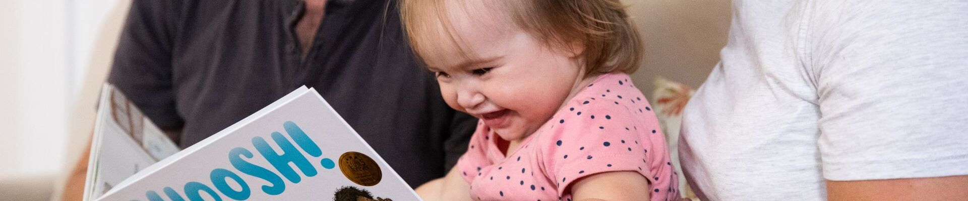 Parents reading the book Shoosh with their child
