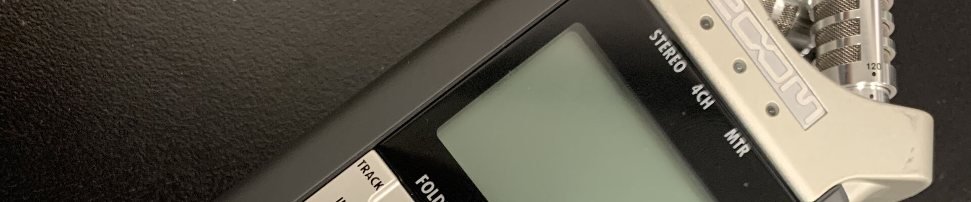 Close up crop of a Zoom audio recorder on a black tabletop