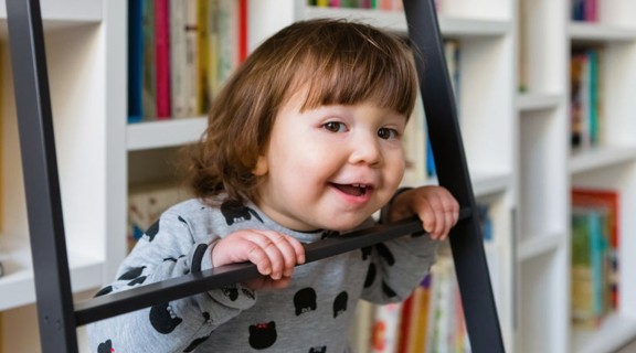 Child at the library in front of books